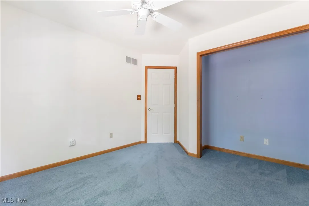 Unfurnished bedroom featuring carpet, ceiling fan, and a closet