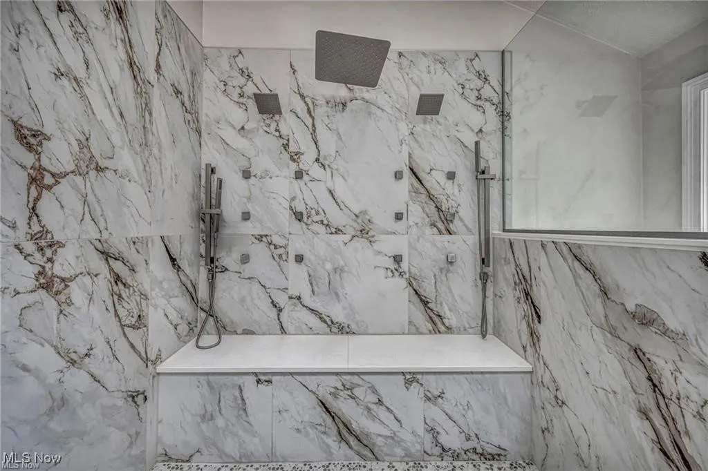Full bathroom with a marble finish shower