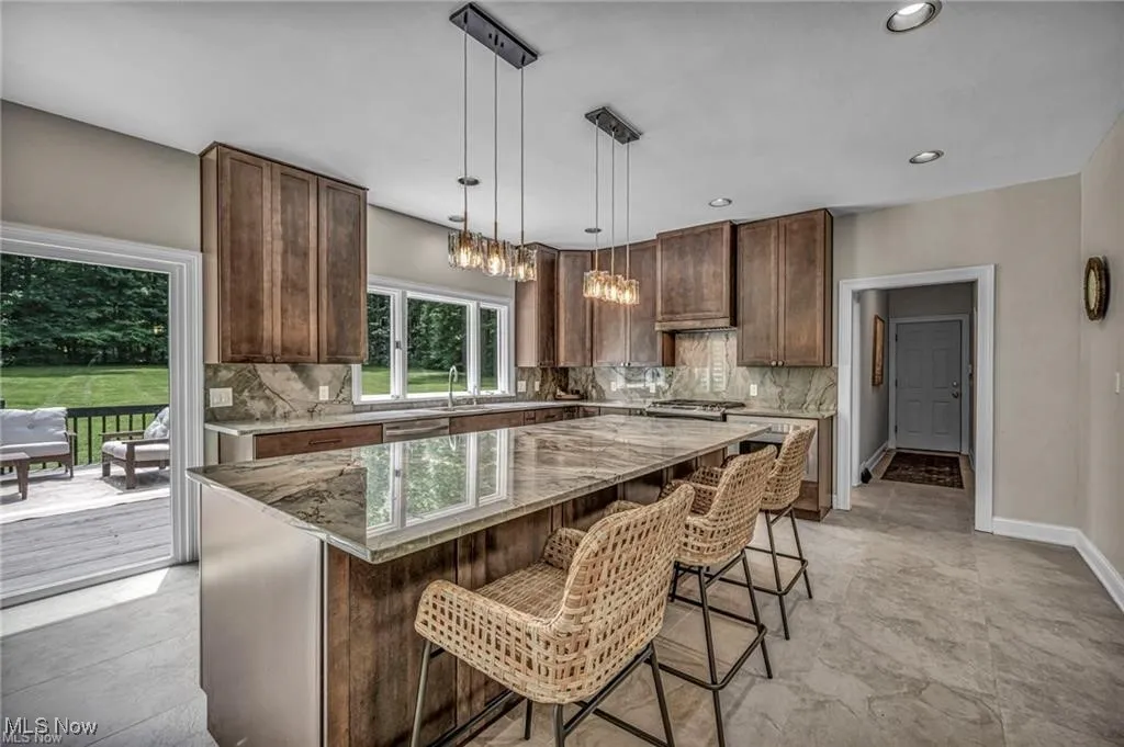 Kitchen with a kitchen breakfast bar, backsplash, decorative light fixtures, and recessed lighting