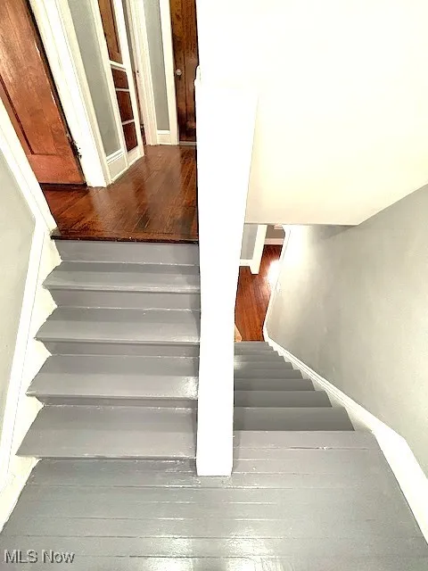 Stairs with wood-type flooring and baseboards