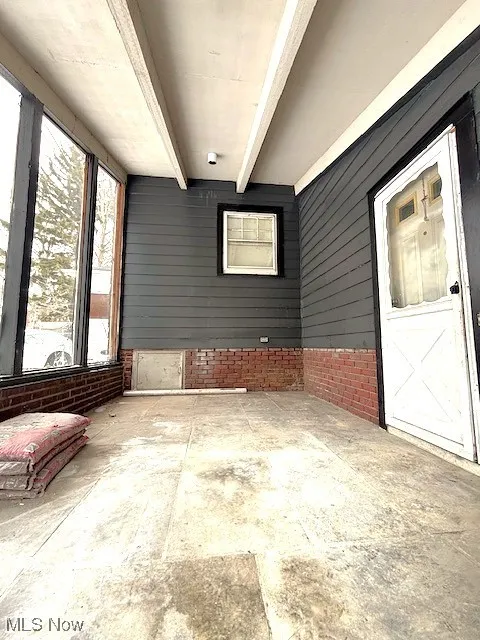 Unfurnished sunroom with beamed ceiling