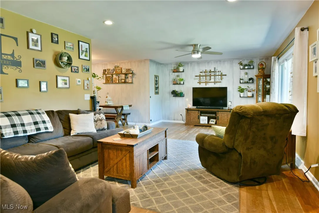 Living room with wood finished floors, recessed lighting, and ceiling fan