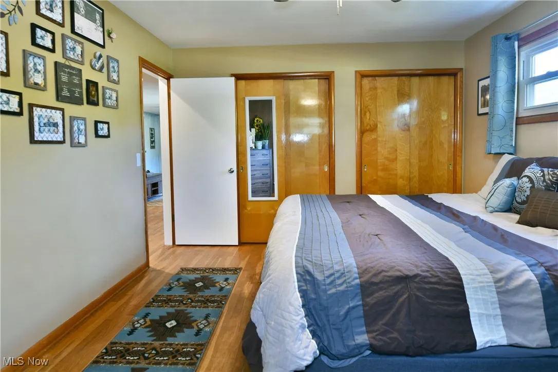 Bedroom with wood finished floors, ceiling fan, and a closet