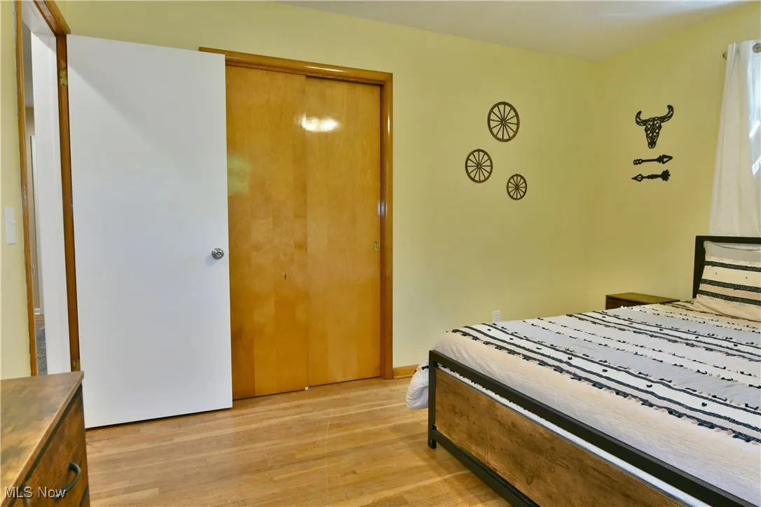 Bedroom with light wood-style floors and a closet
