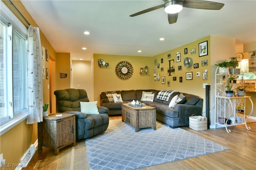 Living room with recessed lighting, wood finished floors, and a ceiling fan