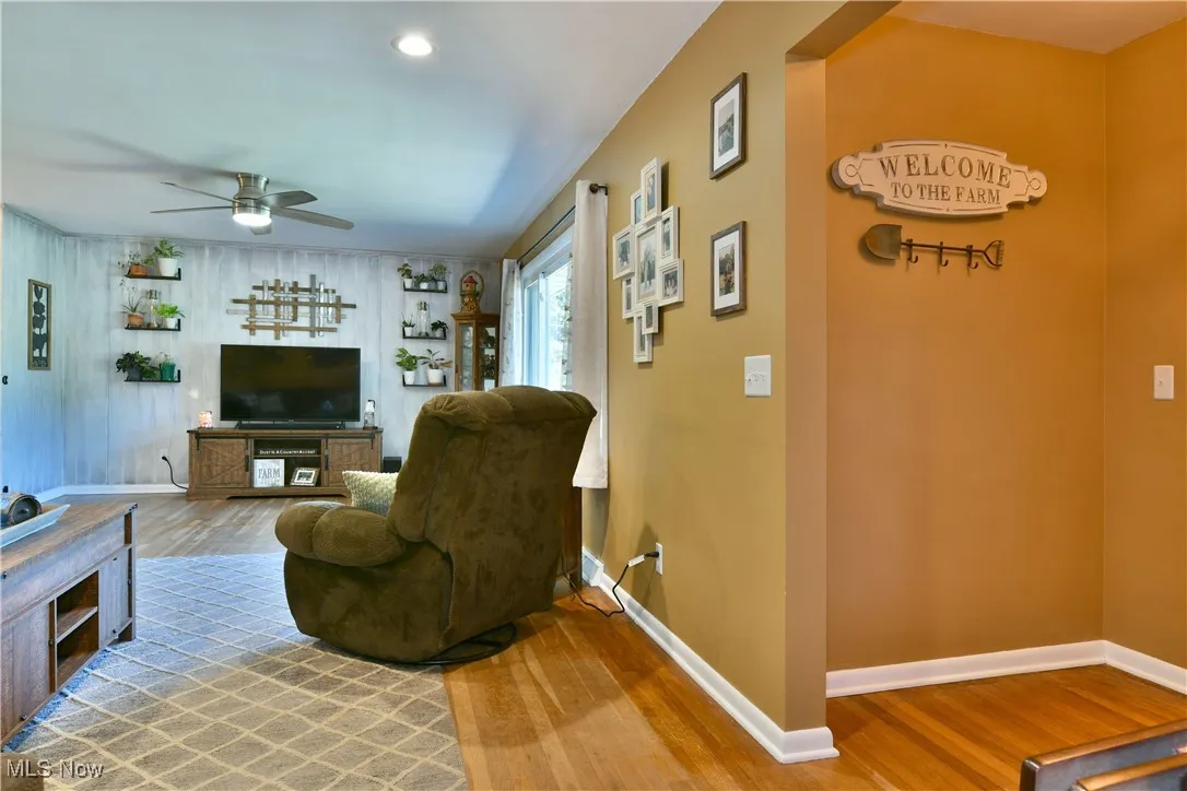Living area with wood finished floors, ceiling fan, and recessed lighting