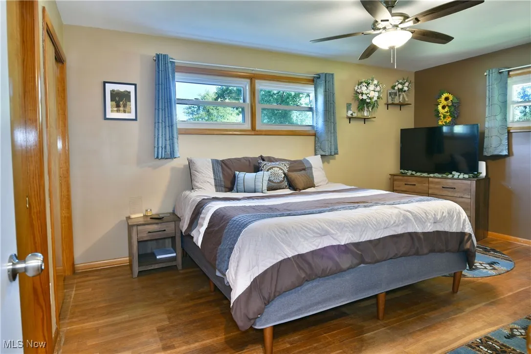 Bedroom with wood finished floors, ceiling fan, and a closet
