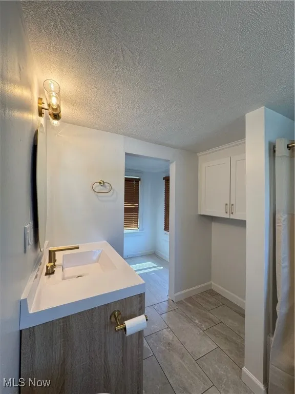 Bathroom featuring vanity and a textured ceiling
