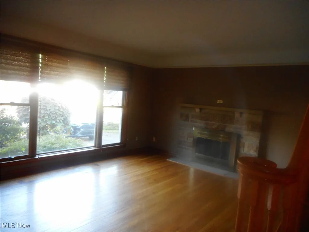Unfurnished living room with a fireplace and wood finished floors