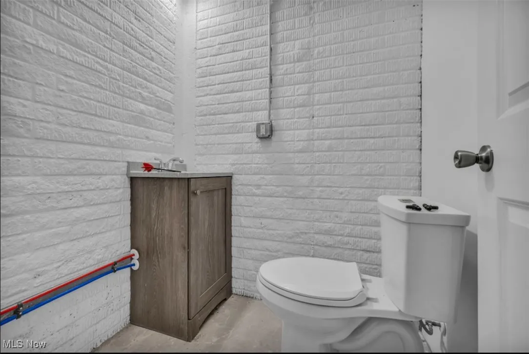 Half bathroom with vanity and concrete flooring