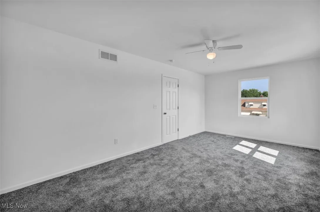 Spare room featuring carpet floors and ceiling fan