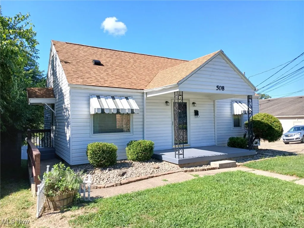 Bungalow featuring a shingled roof, a porch, and a front yard