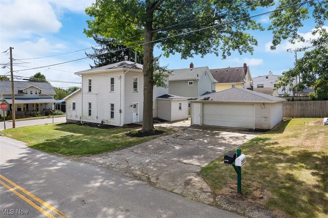 View of front of home with an outdoor structure and a garage