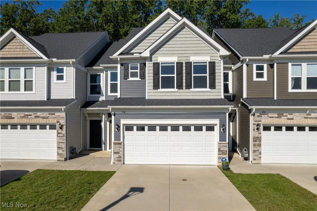Craftsman house with concrete driveway, a shingled roof, and stone siding