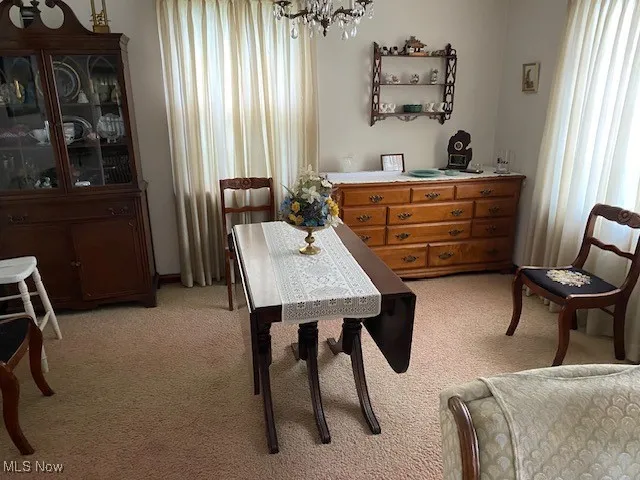Dining room featuring a chandelier and light carpet