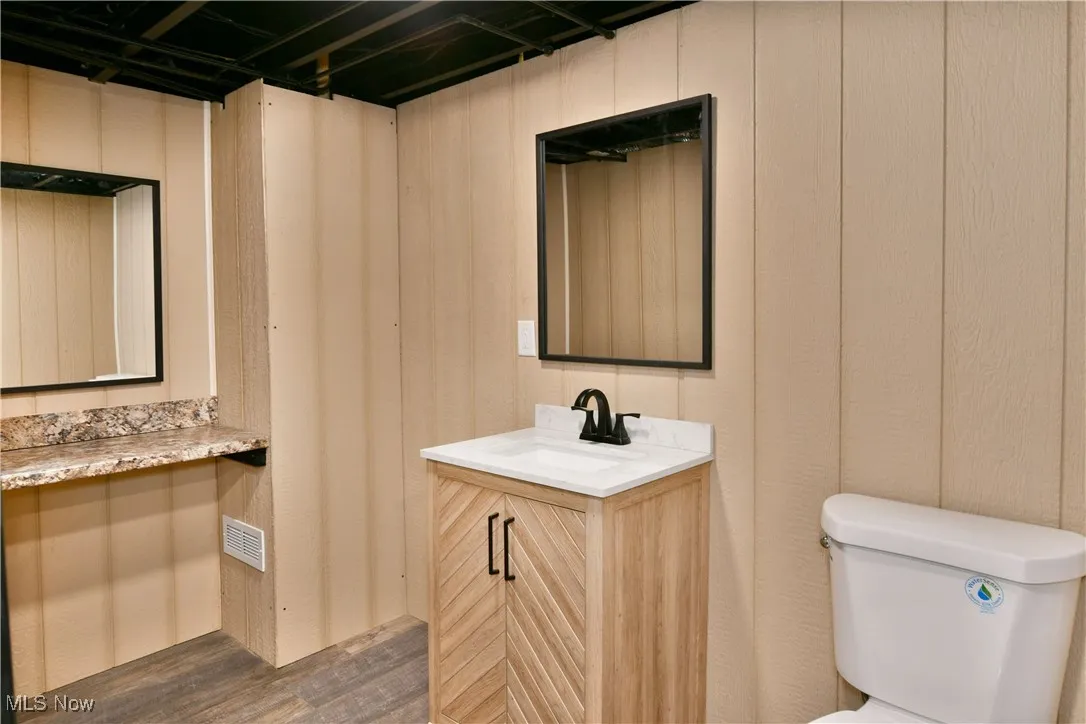 Half bathroom with vanity and dark wood-style floors