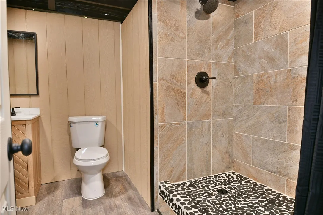 Bathroom featuring vanity, a stall shower, and wood finished floors