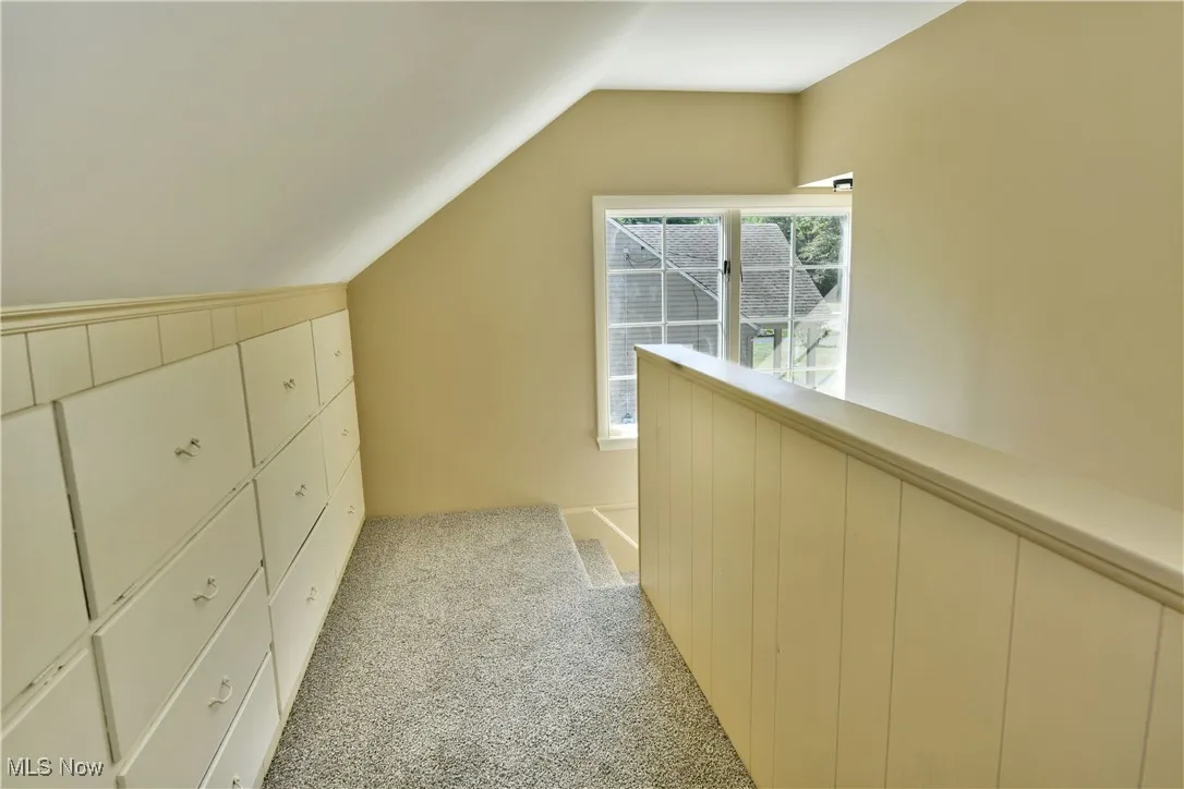 Hall with light carpet and vaulted ceiling