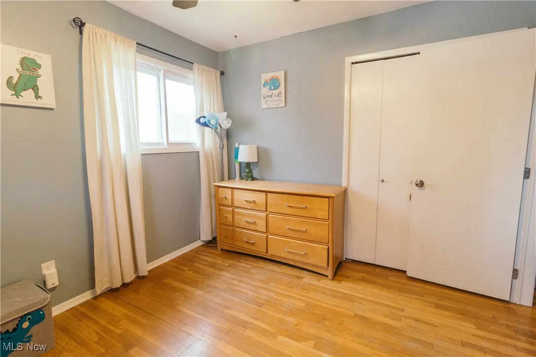 Bedroom featuring light wood-style flooring, a closet, and a ceiling fan