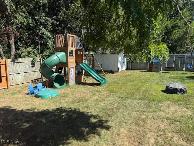 View of play area with a fenced backyard