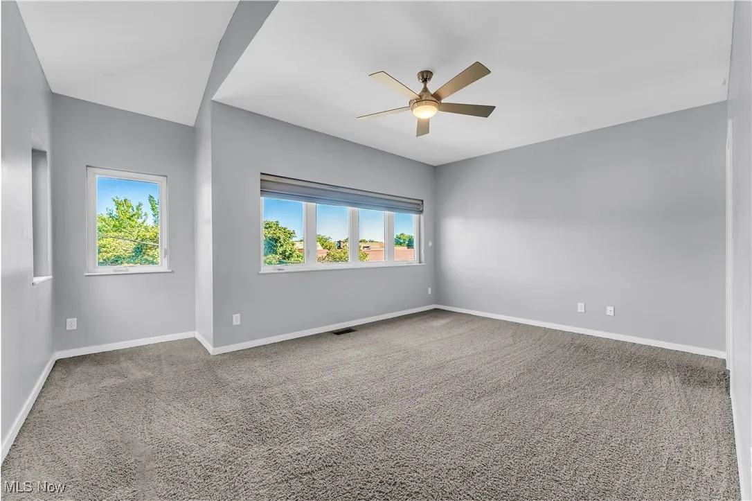Empty room with carpet flooring and a ceiling fan