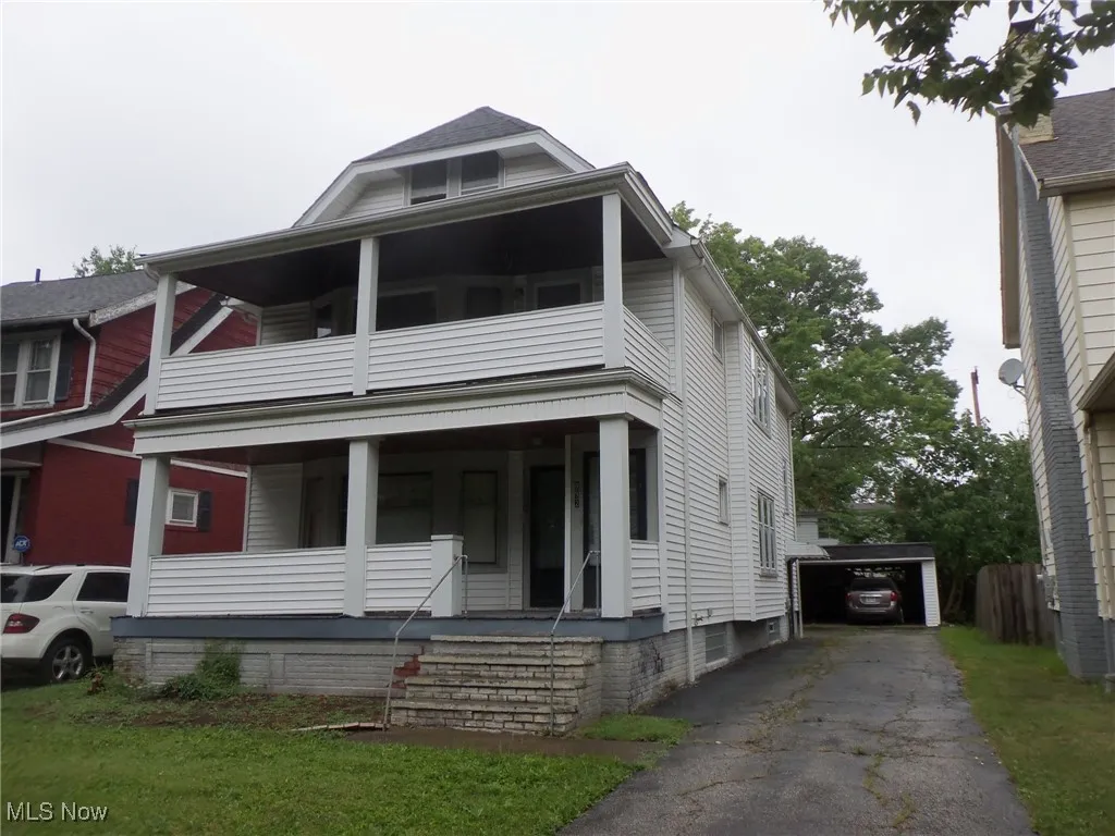 View of front of property featuring a porch, an outbuilding, and a detached garage