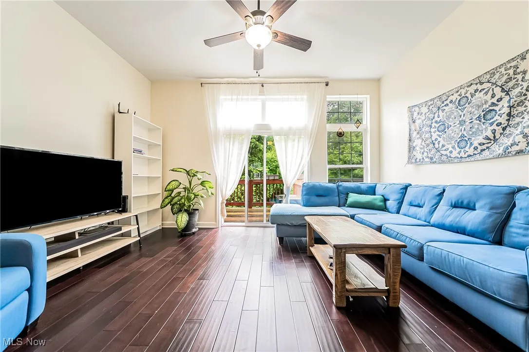 Living room featuring dark wood-style floors and ceiling fan