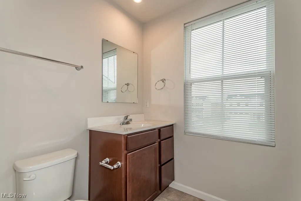Half bathroom featuring vanity, light tile patterned flooring, and recessed lighting