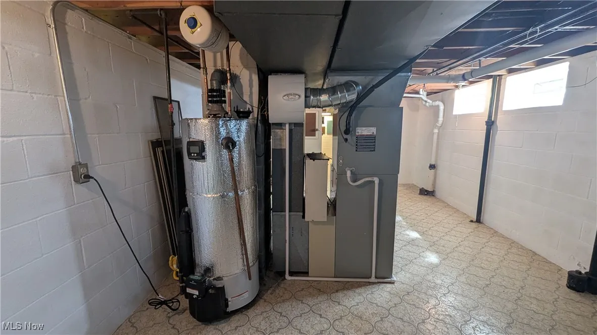 Utility room featuring heating unit and water heater