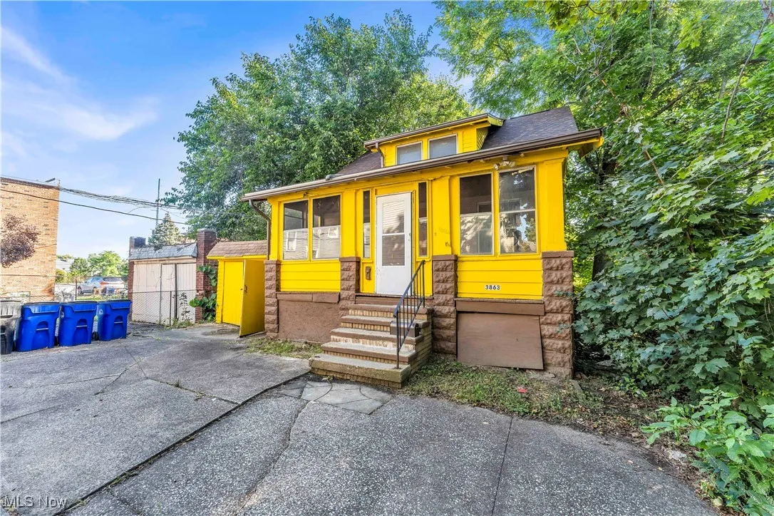 View of front of home with roof with shingles and a sunroom