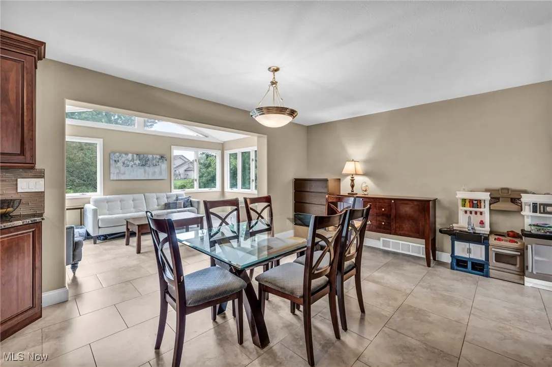 Dining area with light tile patterned flooring and baseboards