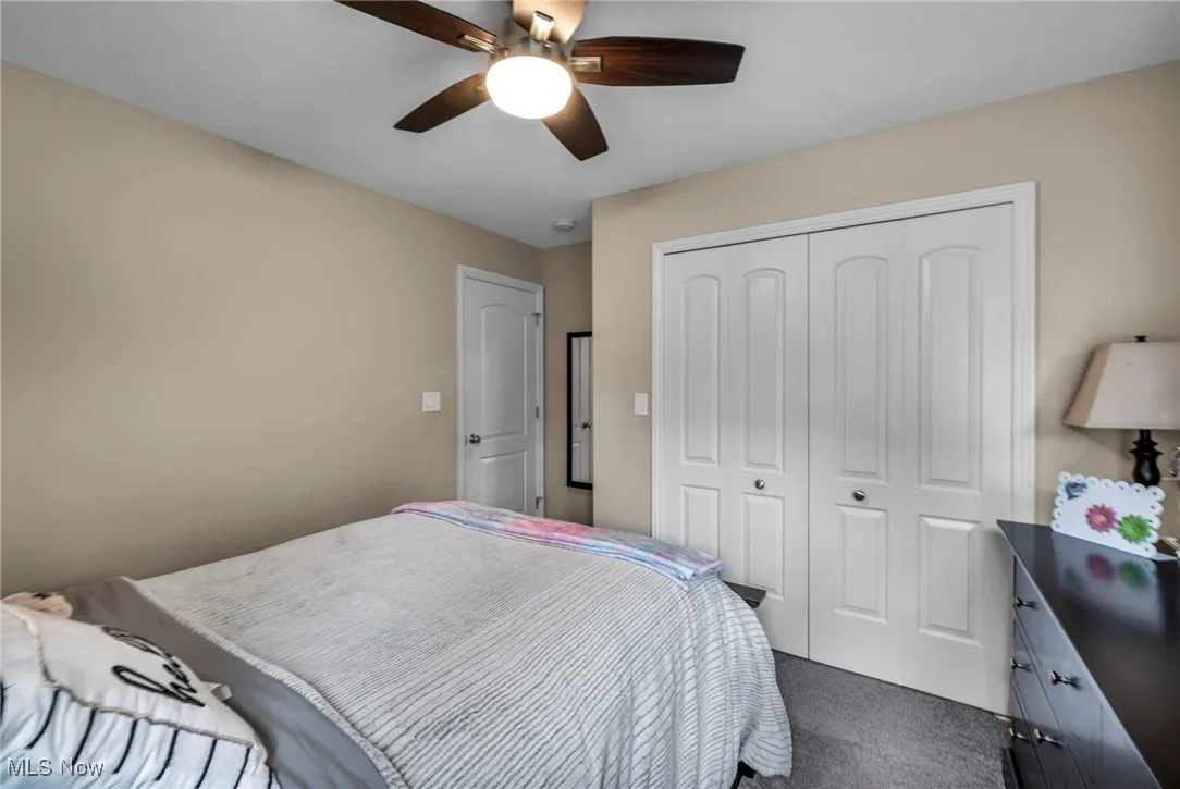 Bedroom featuring carpet floors, ceiling fan, and a closet