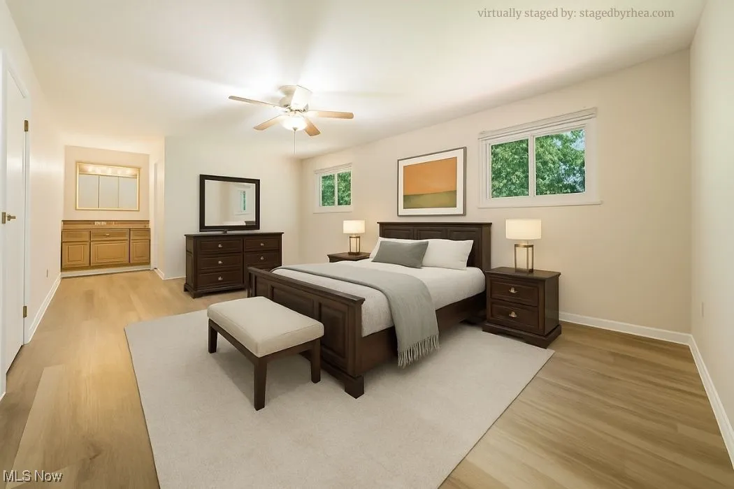 Bedroom with light wood-style flooring, a ceiling fan, and connected bathroom
