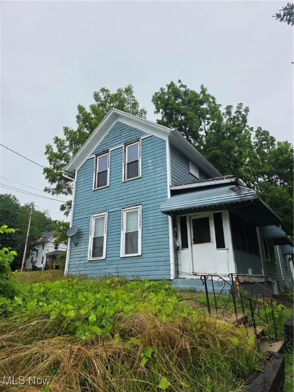 View of side of property featuring covered porch