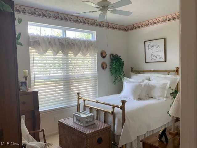 Guest bedroom with ceiling fan, closet and carpet