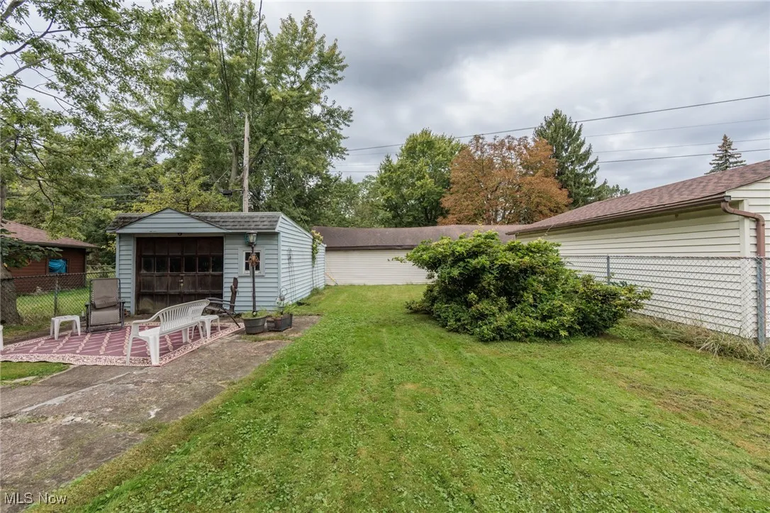 View of yard featuring a sunroom, an outdoor structure, and a garage