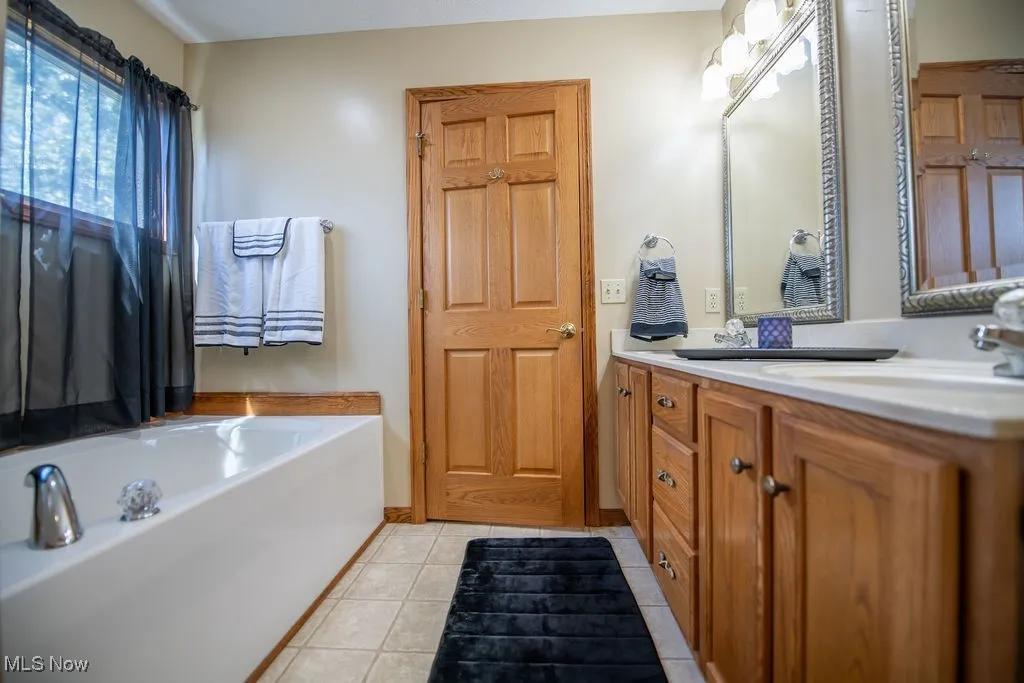 View of master bath area with double vanity and tub