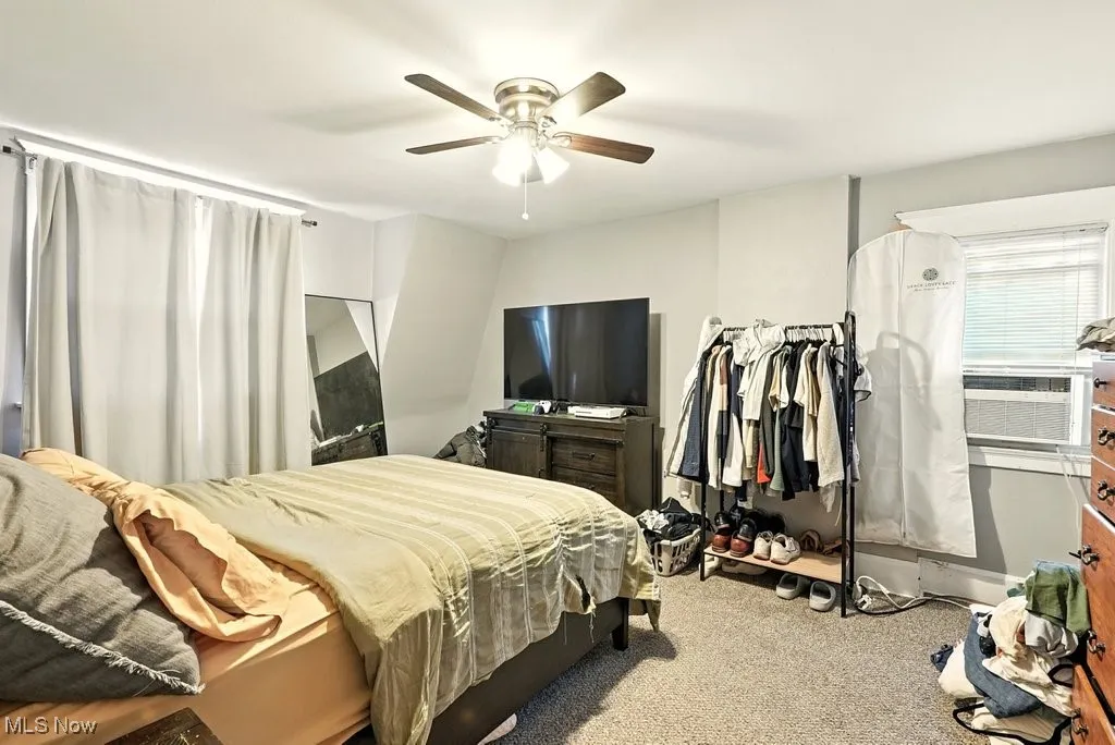 Bedroom with carpet flooring, ceiling fan, and cooling unit