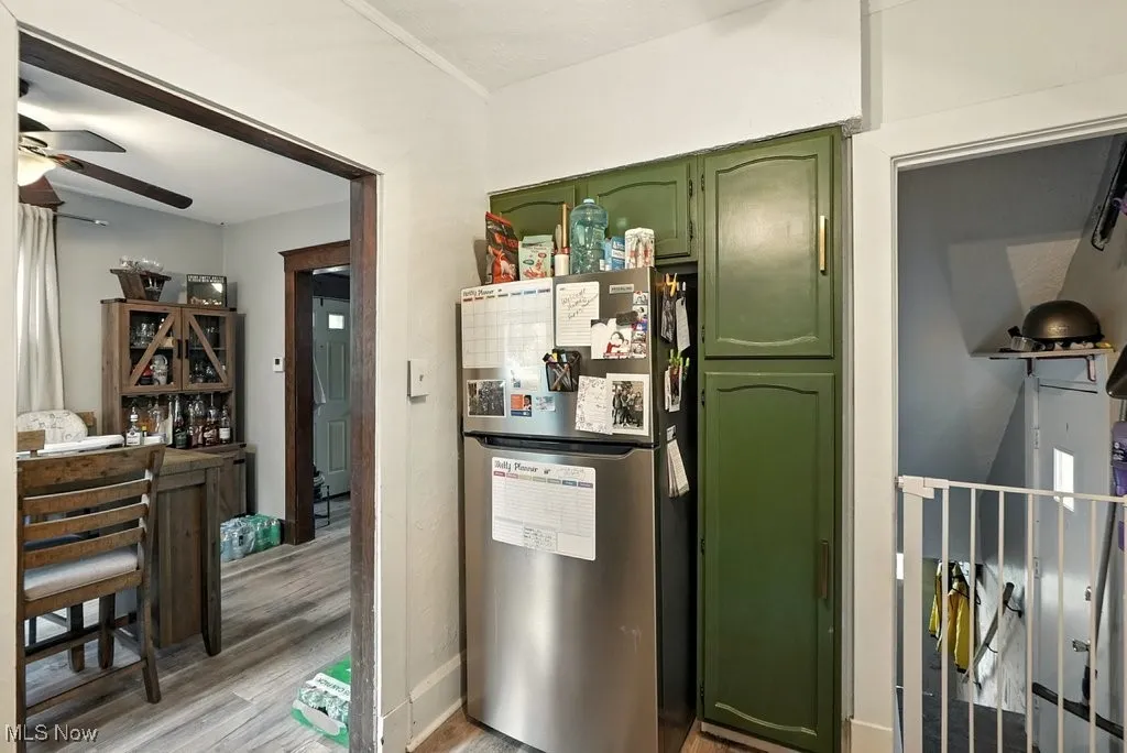 Kitchen featuring green cabinets, freestanding refrigerator, light wood-style floors, and ceiling fan
