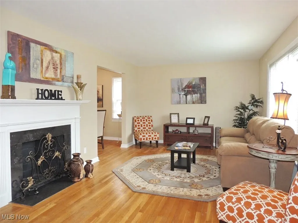 Living room with a fireplace with flush hearth and wood finished floors