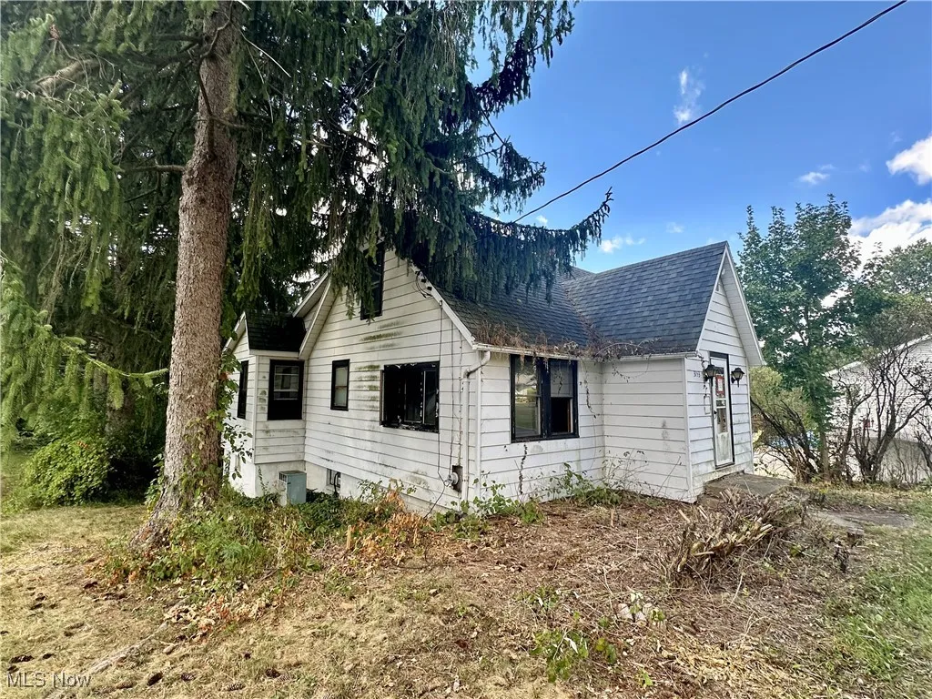 Side view of property with roof with shingles