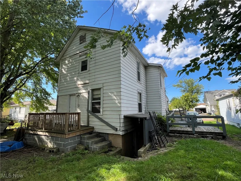 Rear view of property with a wooden deck and a yard