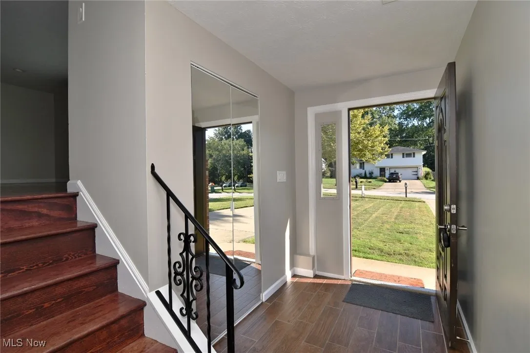 Entryway featuring wood finish floors, plenty of natural light, and stairs