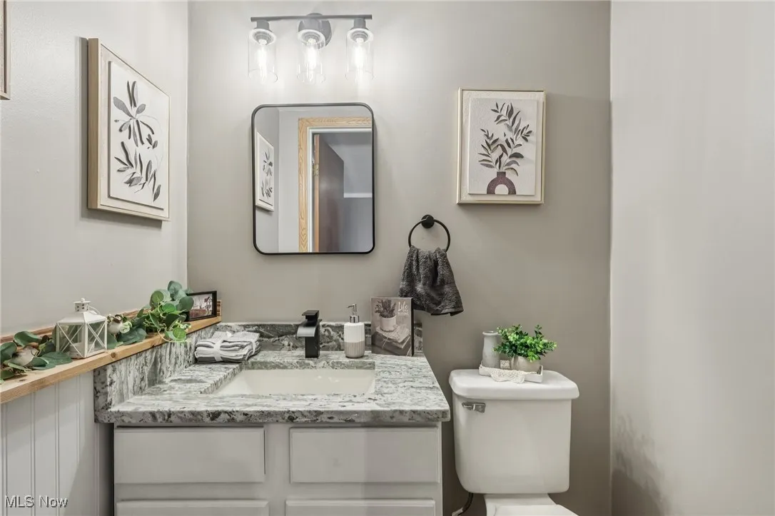 Half bathroom featuring vanity and toilet