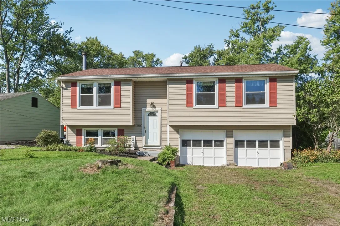 Bi-level home with a front yard, an attached garage, and driveway