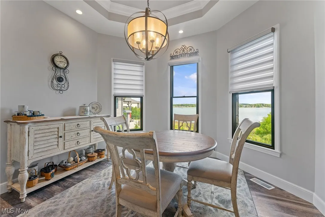 Dining area with recessed tray ceiling detail and appealing light fixture.