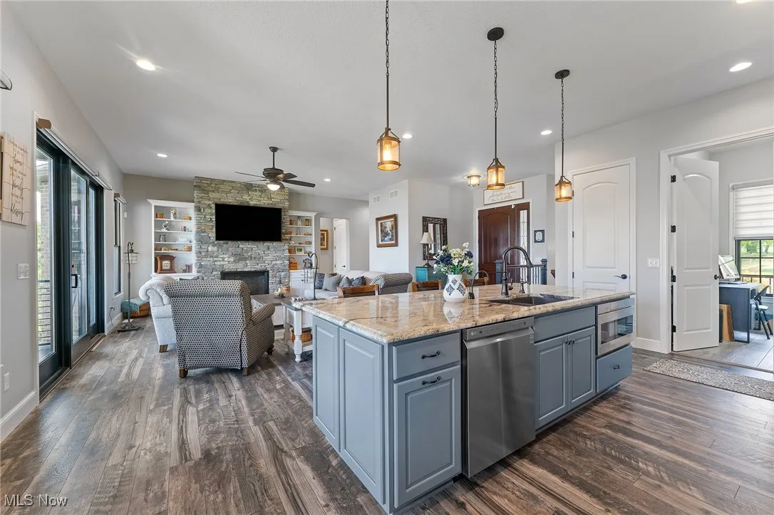 Large island with pendant lights, sink, dishwasher, microwave drawer, and cabinets on both sides for extra storage!