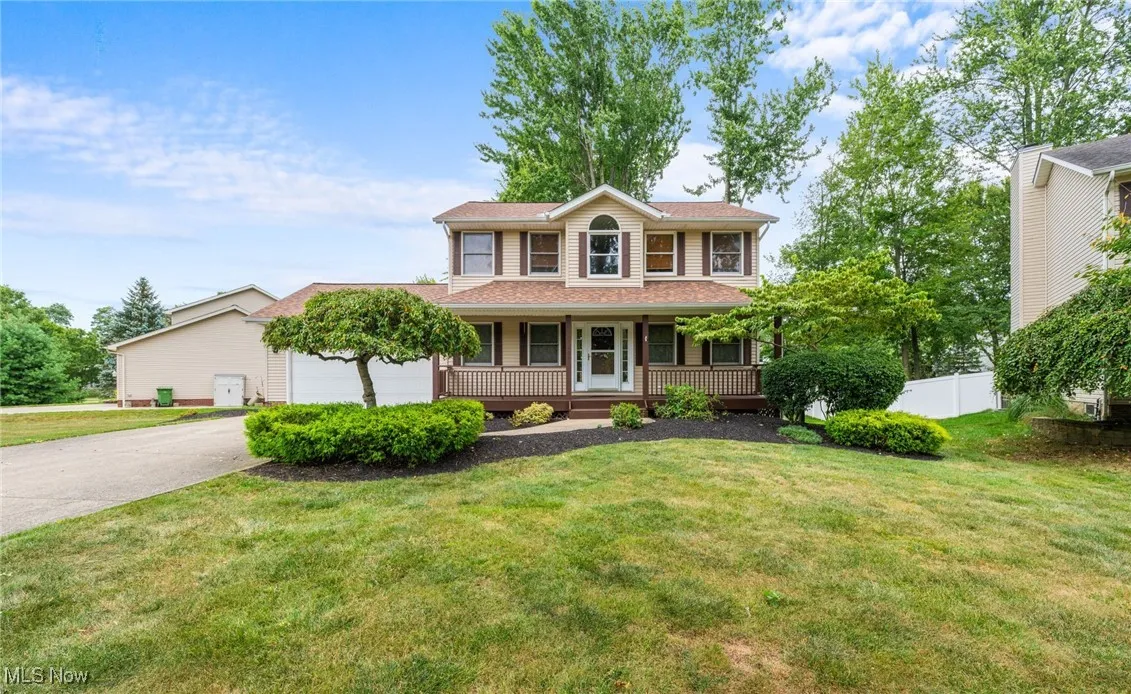 View of front of property featuring a porch, driveway, and a garage