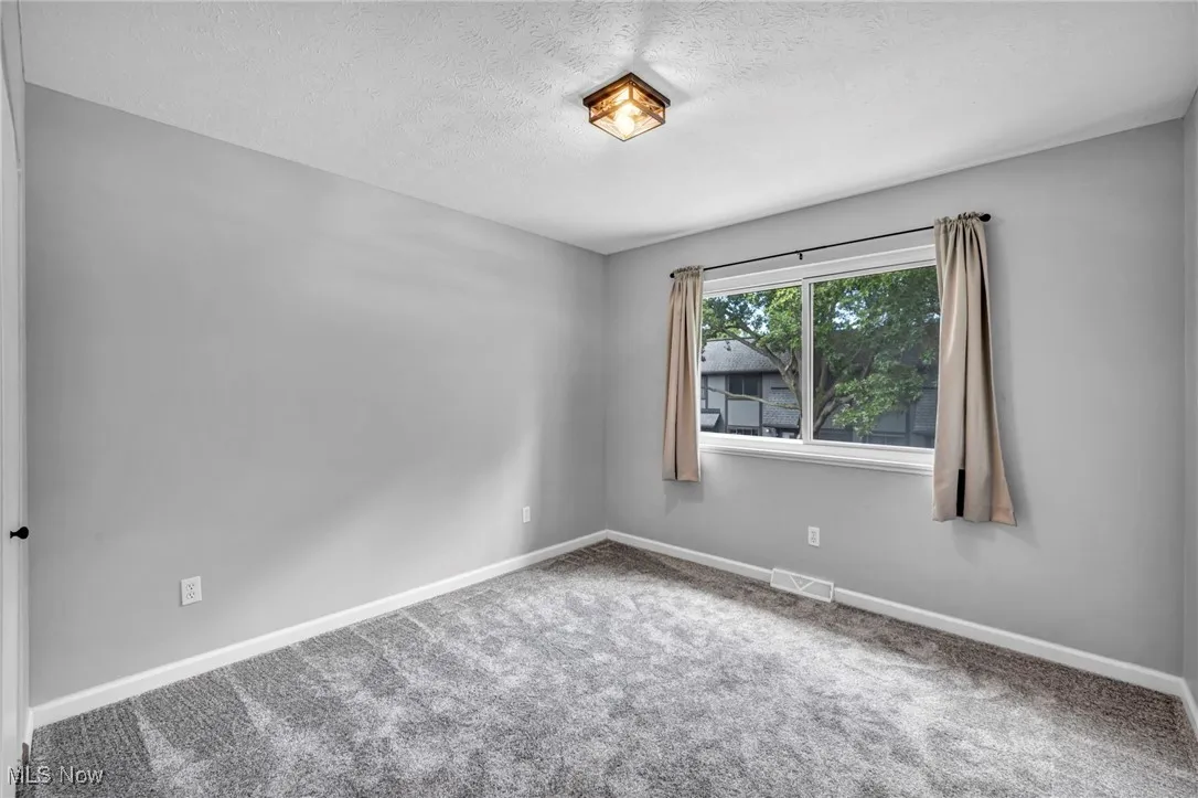 Unfurnished room featuring carpet floors and a textured ceiling