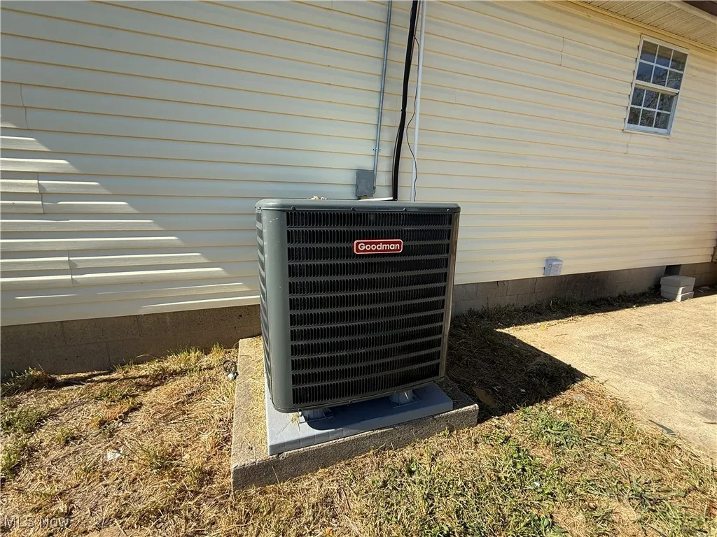 Exterior view of a central AC unit and crawl space